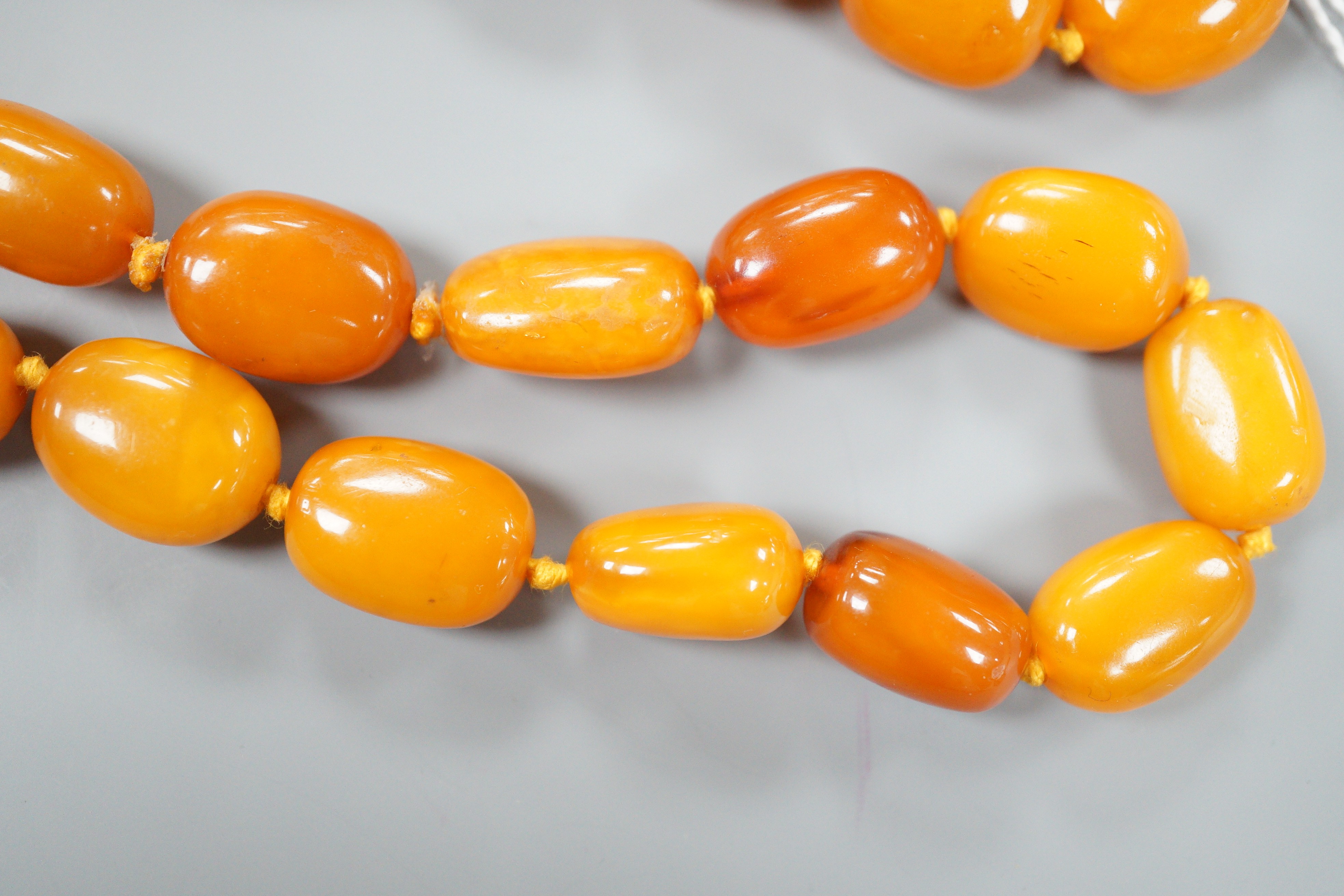 A single strand oval amber bead necklace, 90cm, gross 81 grams